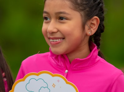 Girls on the Run participant and adult smile outdoors 